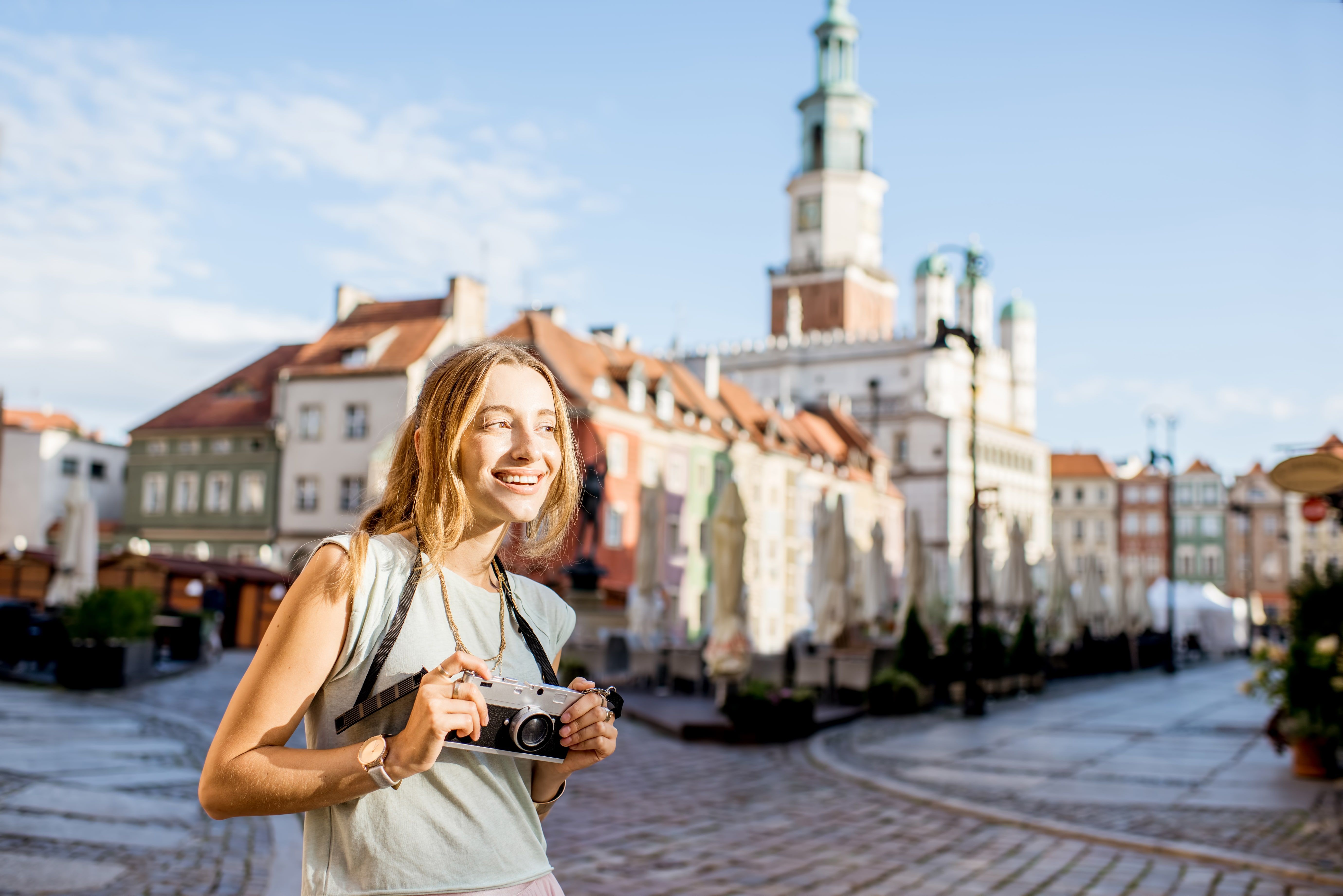 porait-young-woman-tourist-traveling-old-market-sqaure-poznan-city-morning-light-poland-min.jpg